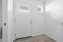 Entryway featuring a paneled door with an upper window, wood-finish flooring, a wall-mounted coat rack, and white trim - 64 17832 78 Street, Edmonton, AB  - Indoor Photo Showing Other Room 