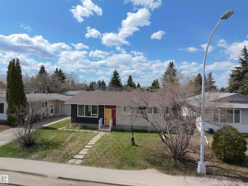 Single-story residence featuring a dark facade with stone accents and a contrasting red and yellow entry - 3912 108 Street, Edmonton, AB - Outdoor