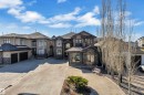 Contemporary residence featuring a multi-tone stucco and stone facade, multiple large windows, a prominent two-car garage, and a concrete driveway - 10915 175 Avenue, Edmonton, AB  - Outdoor With Facade 