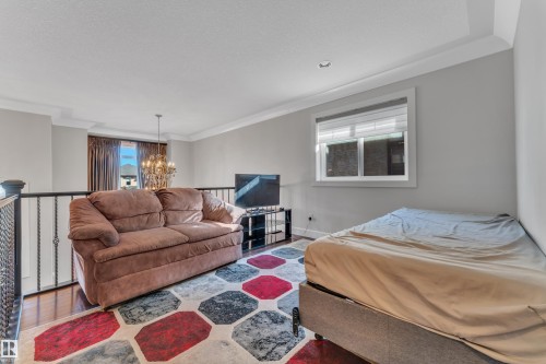 Upper-level room featuring wood-finish flooring, a window with blinds, and painted walls - 10915 175 Avenue, Edmonton, AB - Indoor