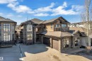 Contemporary home featuring a stone facade, stucco accents, multi-pane windows, a private balcony with railing, and a two-car garage - 10915 175 Avenue, Edmonton, AB  - Outdoor With Facade 