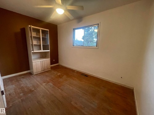 Room with wood-finish flooring, a built-in display cabinet, and a ceiling fan - 13804 132 Avenue, Edmonton, AB - Indoor Photo Showing Other Room