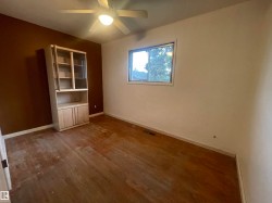 Room with wood-finish flooring, a built-in display cabinet, and a ceiling fan - 