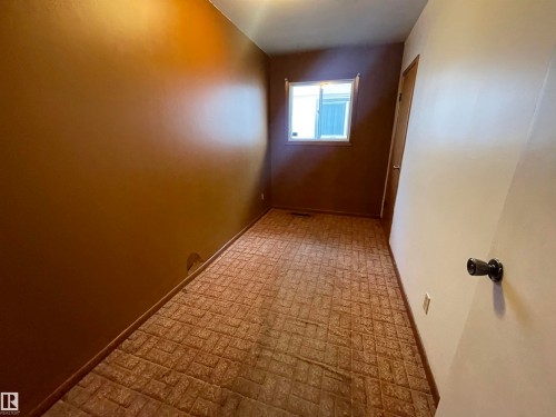 Room featuring textured brown flooring, neutral wall tones, and a window providing natural light - 13804 132 Avenue, Edmonton, AB - Indoor Photo Showing Other Room