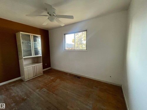 Room featuring a ceiling fan, a window, and wood-finish flooring - 13804 132 Avenue, Edmonton, AB - Indoor Photo Showing Other Room
