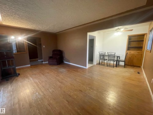 Open-concept living space with wood-finish flooring extending into the dining area - 13804 132 Avenue, Edmonton, AB - Indoor