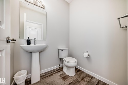 Pedestal sink with a polished chrome faucet and an illuminated mirror - 4609 Alwood Way, Edmonton, AB - Indoor Photo Showing Bathroom