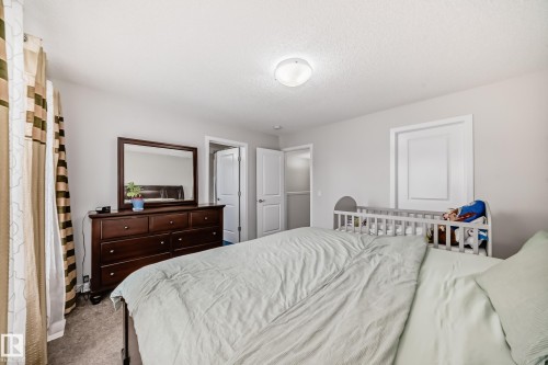 Carpeted bedroom featuring neutral wall tones, a ceiling-mounted light fixture, white trim around windows, and white interior doors - 4609 Alwood Way, Edmonton, AB - Indoor Photo Showing Bedroom