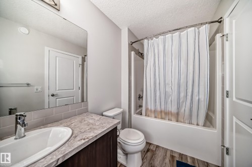 Bathroom featuring a full-size vanity with a basin sink, subway tile backsplash, and a large mirror - 4609 Alwood Way, Edmonton, AB - Indoor Photo Showing Bathroom