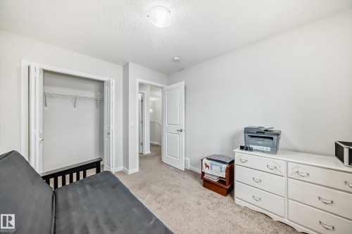 Neutral wall paint, carpet flooring, bi-fold closet doors with wire shelving, and a flush mount ceiling light fixture - 4609 Alwood Way, Edmonton, AB - Indoor