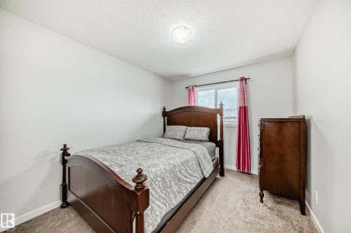 Room featuring a window with a dark frame, neutral carpet flooring, and a white ceiling with a flush-mount light fixture - 4609 Alwood Way, Edmonton, AB - Indoor Photo Showing Bedroom