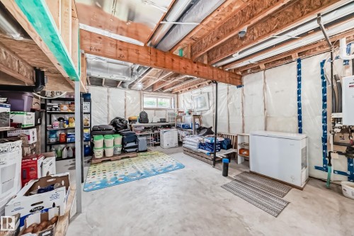Unfinished basement space featuring exposed wooden joists, concrete flooring, perimeter wall insulation, and a visible window - 4609 Alwood Way, Edmonton, AB - Indoor Photo Showing Basement
