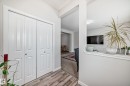 Hallway featuring bi-fold panel doors, wood-finish flooring, and a half-wall partition - 4609 Alwood Way, Edmonton, AB  - Indoor 