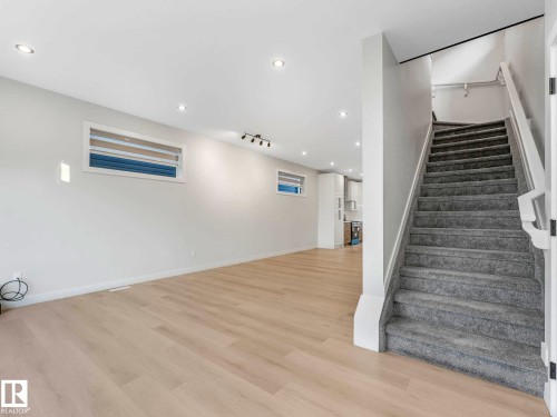 Bright main living area featuring light wood-finish flooring, recessed lighting, and a neutral color palette - 15731 109 Avenue, Edmonton, AB - Indoor Photo Showing Other Room