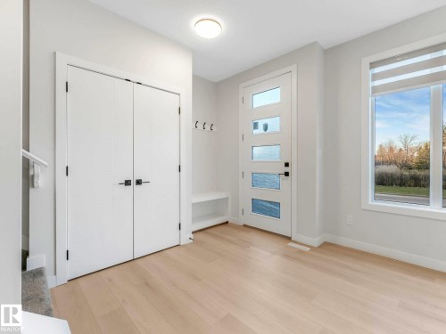 Entryway featuring light wood-finish flooring and a modern front door with frosted glass panels - 15731 109 Avenue, Edmonton, AB - Indoor Photo Showing Other Room