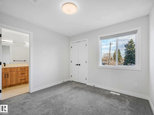 Bright room featuring light grey carpet flooring, white walls, and a large window providing natural illumination - 15731 109 Avenue, Edmonton, AB - Indoor Photo Showing Other Room