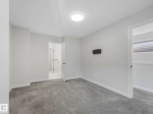 Neutral-toned carpeting paired with white walls, baseboards, and trim - 15731 109 Avenue, Edmonton, AB - Indoor Photo Showing Other Room