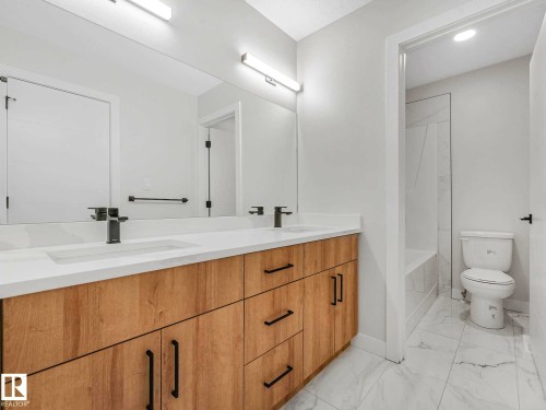 Double vanity with a white countertop and wood-finish cabinetry - 15731 109 Avenue, Edmonton, AB - Indoor Photo Showing Bathroom