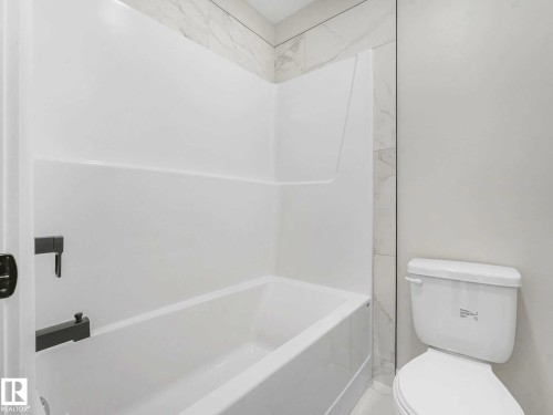 White fiberglass tub and shower combination with a single-handle faucet - 15731 109 Avenue, Edmonton, AB - Indoor Photo Showing Bathroom
