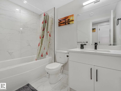 Bathroom featuring a white vanity with a light-toned countertop, a built-in sink, and a matte black faucet - 15731 109 Avenue, Edmonton, AB - Indoor Photo Showing Bathroom
