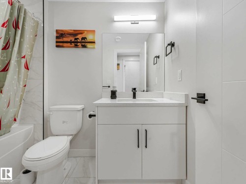 White vanity with integrated sink and chrome faucet - 15731 109 Avenue, Edmonton, AB - Indoor Photo Showing Bathroom