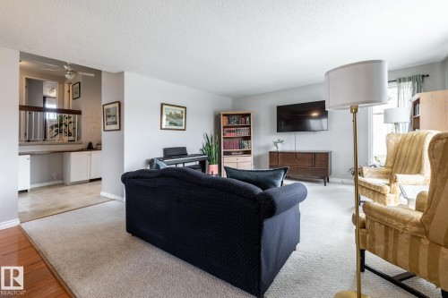 Open living area featuring carpet flooring, light gray wall paint, and natural light from a window - 3608 16A Avenue, Edmonton, AB - Indoor Photo Showing Living Room