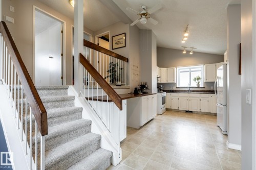 Carpeted staircase to the upper level with wood-finish handrails and white balusters - 3608 16A Avenue, Edmonton, AB - Indoor Photo Showing Other Room