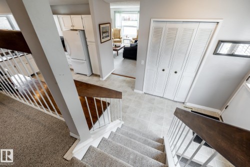 Carpeted staircase with wood-finish handrails and white balusters - 3608 16A Avenue, Edmonton, AB - Indoor Photo Showing Other Room