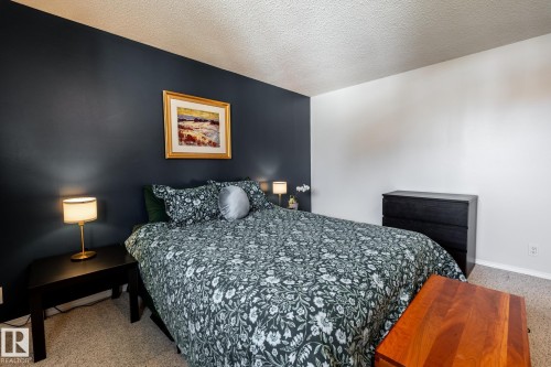 Bedroom featuring a single dark accent wall, textured ceiling, and light carpet flooring - 3608 16A Avenue, Edmonton, AB - Indoor Photo Showing Bedroom