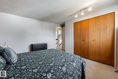Spacious room featuring light-toned carpeting, neutral wall paint, and a textured ceiling - 3608 16A Avenue, Edmonton, AB - Indoor Photo Showing Bedroom