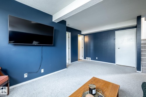 Spacious room with blue accent walls and light-toned carpeting - 3608 16A Avenue, Edmonton, AB - Indoor Photo Showing Other Room