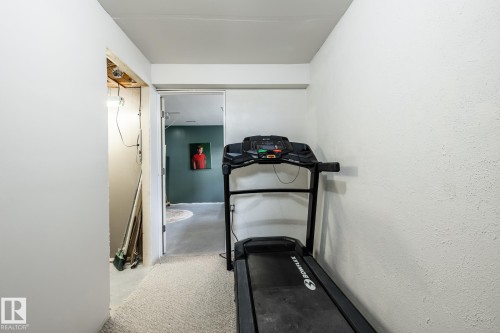 Carpeted hallway with textured white walls, leading to an interior doorway - 3608 16A Avenue, Edmonton, AB - Indoor
