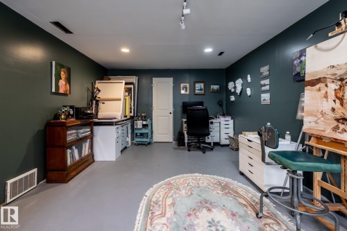 Spacious room featuring dark green accent walls and light gray flooring - 3608 16A Avenue, Edmonton, AB - Indoor