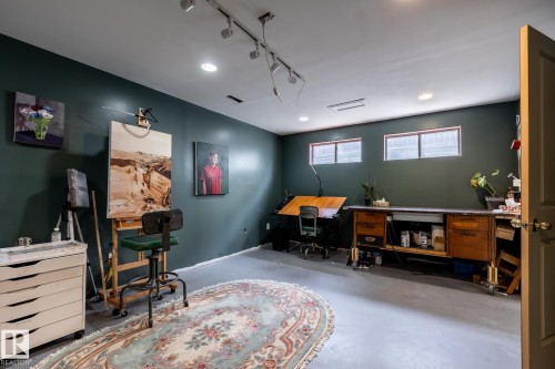 Spacious basement room serves as a hobby room, featuring dark green walls, recessed lighting, and track lighting - 3608 16A Avenue, Edmonton, AB - Indoor