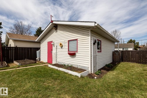 Detached garage with light-colored siding, a red door, and a red-trimmed window box - 3608 16A Avenue, Edmonton, AB - Outdoor With Exterior