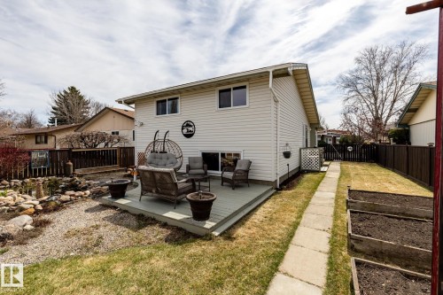 Spacious backyard featuring a deck, concrete pathway, raised garden beds, a fish pond and rock landscaping - 3608 16A Avenue, Edmonton, AB - Outdoor With Exterior