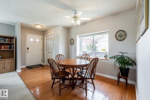 Entryway and dining room featuring wood-finish flooring, a white paneled entry door with frosted glass inserts, and an adjacent closet with bi-fold doors - 3608 16A Avenue, Edmonton, AB - Indoor Photo Showing Dining Room
