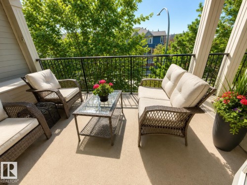 Outdoor balcony featuring a textured floor, black metal railing, and architectural support beams - 301 9803 96A Street, Edmonton, AB - Outdoor With Exterior