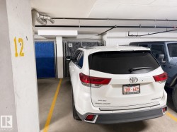 Dedicated parking stall with concrete flooring and overhead utility piping - 
