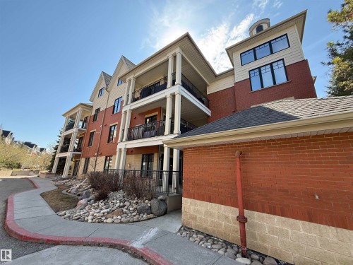 Multi-story residential building featuring brick and siding facades, private balconies with black railings, and a prominent cupola - 301 9803 96A Street, Edmonton, AB - Outdoor With Balcony