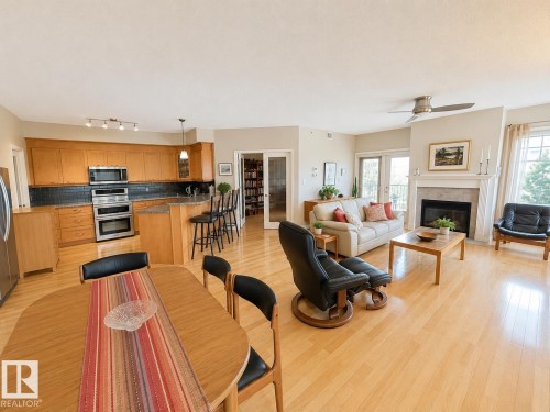 Open-concept living space featuring wood-finish flooring throughout - 301 9803 96A Street, Edmonton, AB - Indoor With Fireplace