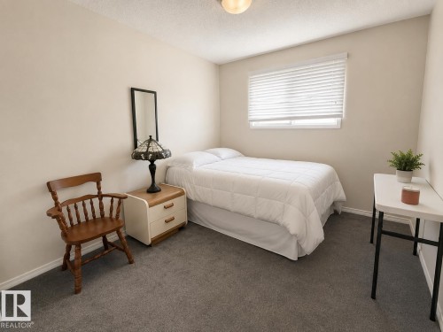 Neutral-toned room featuring a single window with blinds, light-colored walls, and grey carpet - 5712 101 Avenue, Edmonton, AB - Indoor Photo Showing Bedroom