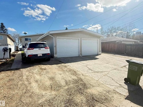 Property featuring a dual garage with white panel doors and stucco exterior - 5712 101 Avenue, Edmonton, AB - Outdoor With Exterior