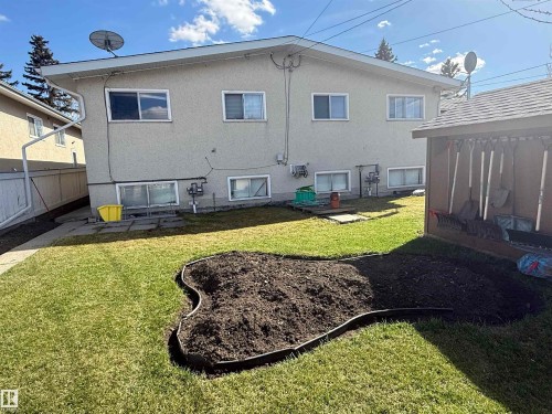 Rear exterior with textured stucco siding and multiple windows - 5712 101 Avenue, Edmonton, AB - Outdoor With Exterior