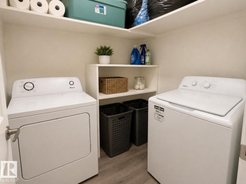 Dedicated laundry area featuring a white top-load washer and front-load dryer - 5712 101 Avenue, Edmonton, AB - Indoor Photo Showing Laundry Room