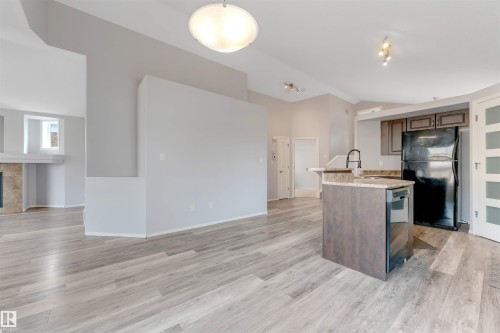 Interior space featuring neutral wall paint, light-colored carpet flooring, a window with horizontal blinds, and a sloped ceiling - 123 Rue Masson, Beaumont, AB - Indoor Photo Showing Other Room