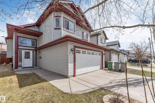 Two-story residence featuring light gray siding and contrasting dark red trim - 123 Rue Masson, Beaumont, AB - Outdoor