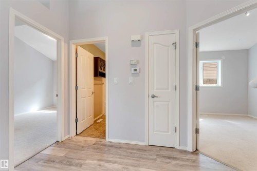 Spacious room featuring vaulted ceilings, light-toned carpeting, and a large window with white trim - 123 Rue Masson, Beaumont, AB - Indoor Photo Showing Other Room