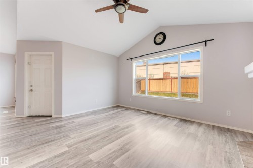 Spacious room with a vaulted ceiling and a three-panel bay window - 123 Rue Masson, Beaumont, AB - Indoor Photo Showing Other Room