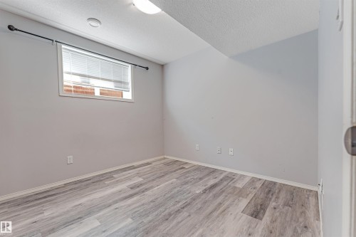 Rear exterior featuring a spacious wood deck, ground-level patio, and fenced backyard - 123 Rue Masson, Beaumont, AB - Outdoor With View